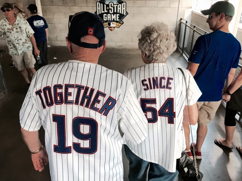 Elderly couple wearing baseball jerseys that combined read "together since 1954" cost basis example