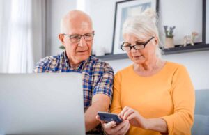 Worried older couple looking at laptop with calculator in hands - cd type annuity featured image